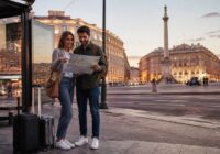 Citytrip met een koppel dat een kaart bekijkt bij een bushalte tijdens het reizen en vakanties vergelijken