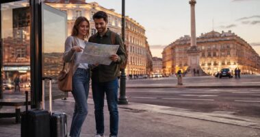Citytrip met een koppel dat een kaart bekijkt bij een bushalte tijdens het reizen en vakanties vergelijken